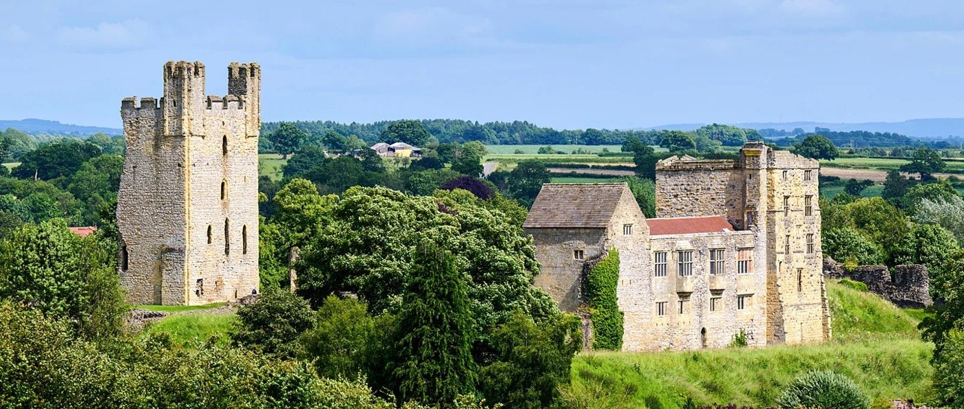 Helmsley Castle ruins set amongst lush green countryside in North Yorkshire